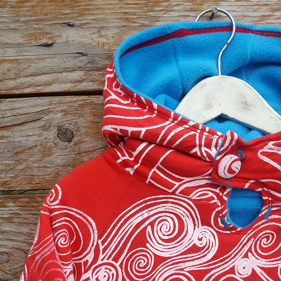 Kid's reversible hoody in turquoise/red - close up Kid's reversible hoody in turquoise/red - close up